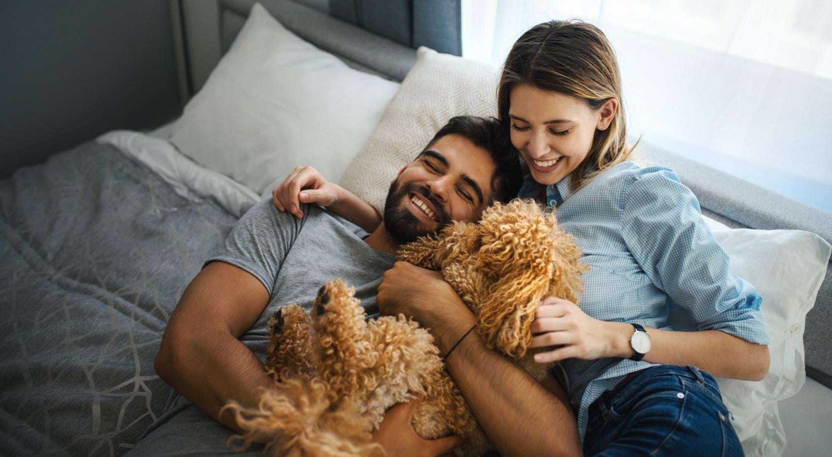 We welcome your pet family a couple of women lying in bed with stuffed animals